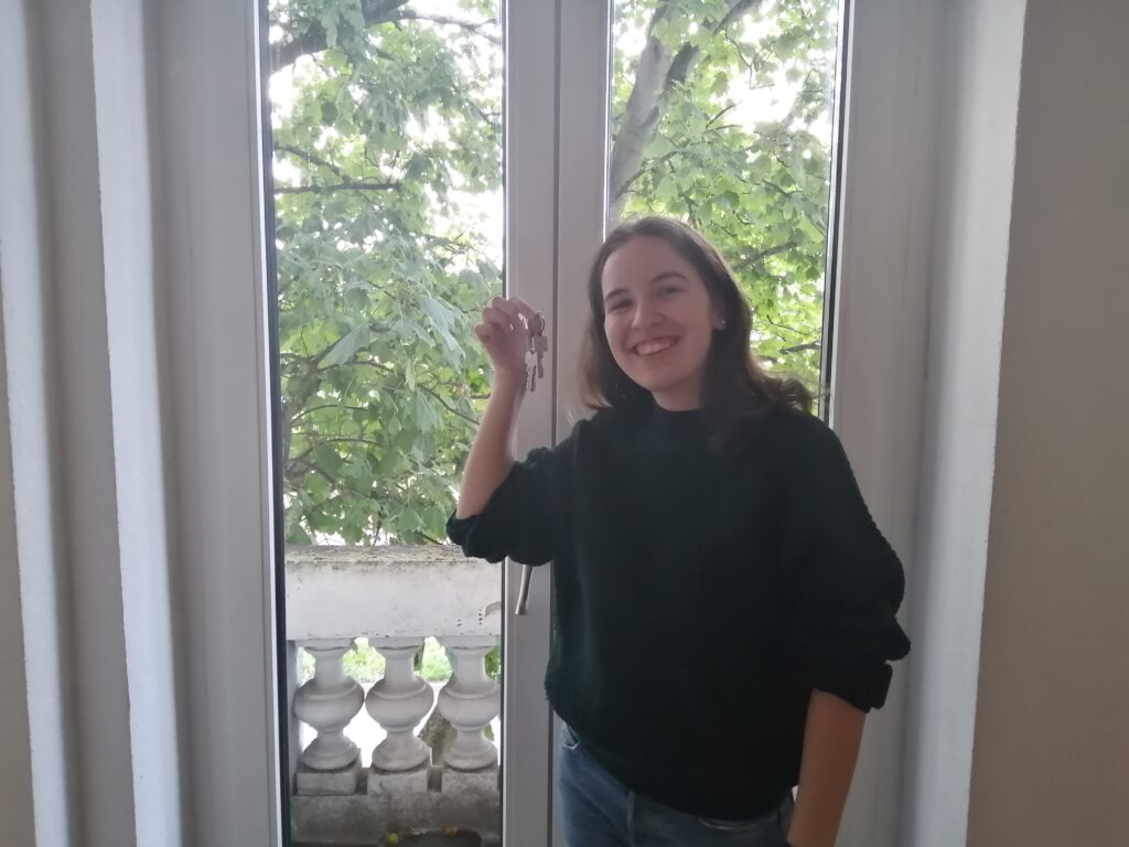 Meine Tochter Johanna steht mit dem Wohnungsschlüssel strahlend vor ihrer Balkontür.
