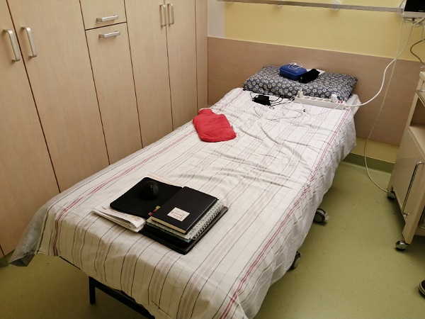 Ein Elternbett im Krankenhaus mit Wärmflasche und Laptop, von mir umfunktioniert zum Schreibtsich